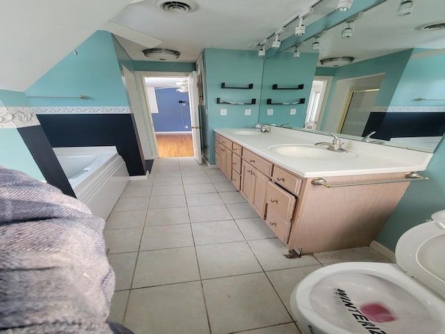 bathroom featuring tile patterned flooring, vanity, and a tub