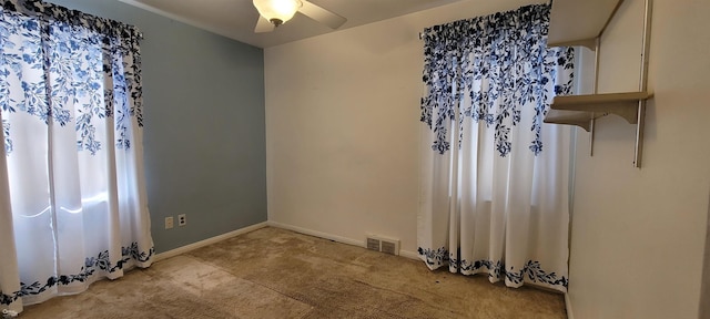 spare room featuring ceiling fan and light colored carpet