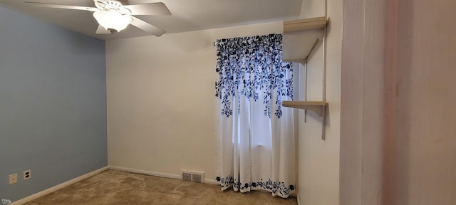 unfurnished room with ceiling fan and carpet