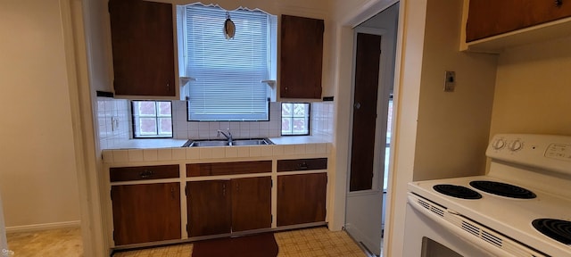 kitchen featuring white range with electric stovetop, sink, decorative backsplash, tile counters, and dark brown cabinetry