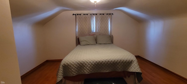 bedroom featuring hardwood / wood-style flooring and vaulted ceiling