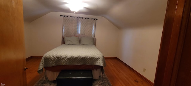 bedroom featuring lofted ceiling and hardwood / wood-style floors