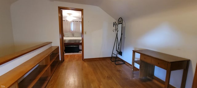 hallway with lofted ceiling and light wood-type flooring