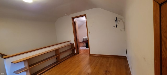 corridor with lofted ceiling and light hardwood / wood-style floors