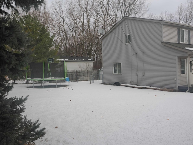 view of property exterior featuring a trampoline and fence