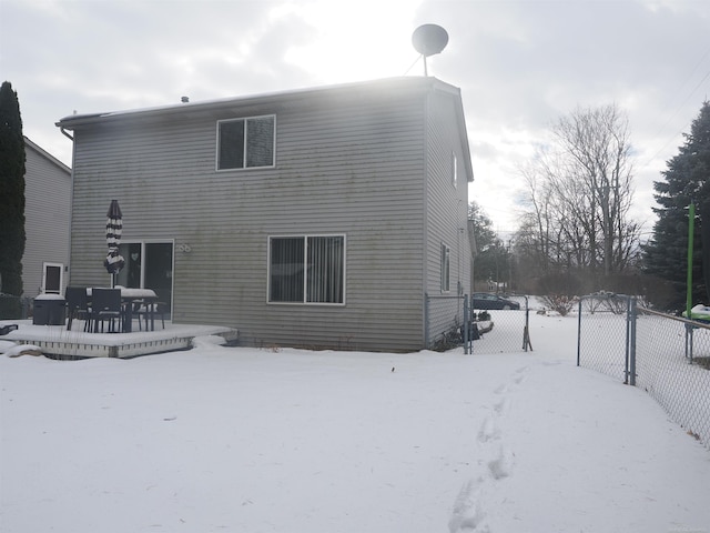 snow covered property with fence