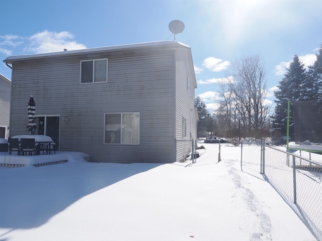 snow covered house with fence