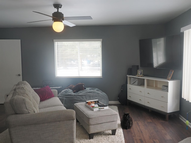 living area featuring a ceiling fan, dark wood-type flooring, and baseboards