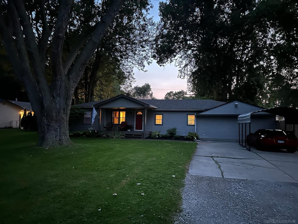 ranch-style house featuring a lawn, a carport, and a porch