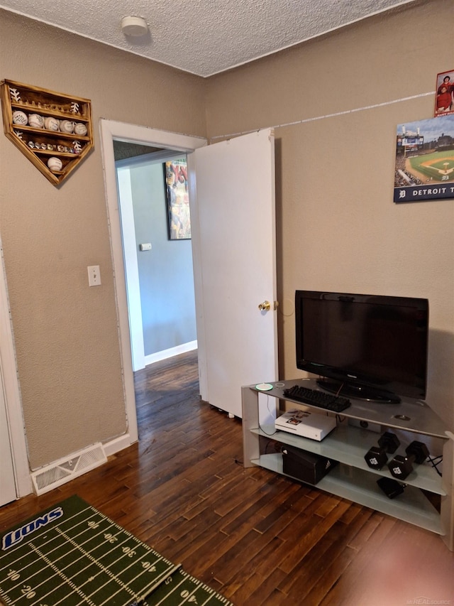 living room with dark wood-type flooring and a textured ceiling