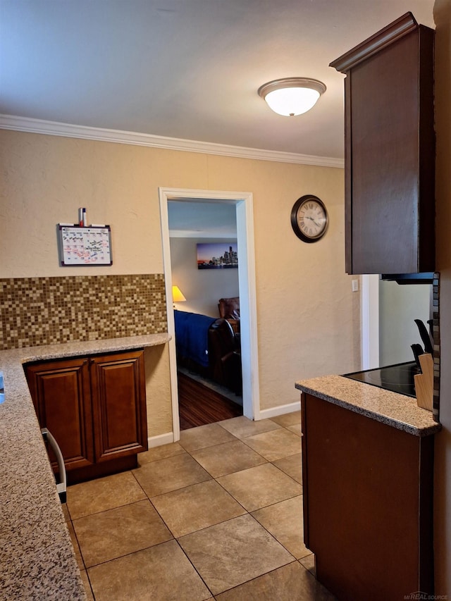 kitchen featuring crown molding, light tile patterned flooring, dark brown cabinets, and backsplash