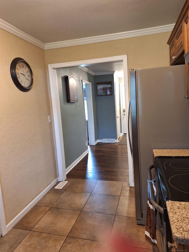 kitchen with electric range oven, crown molding, and dark tile patterned floors