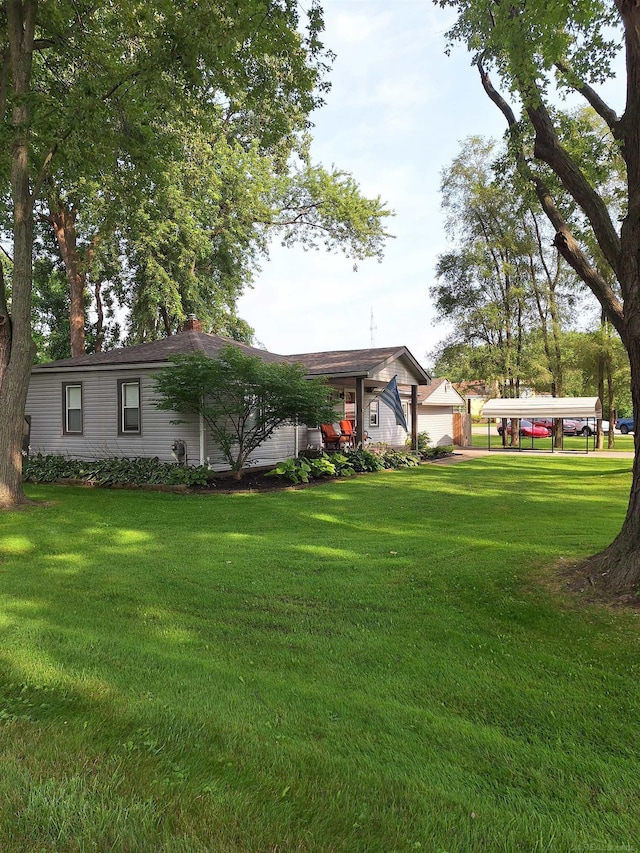 view of yard featuring a carport and a garage