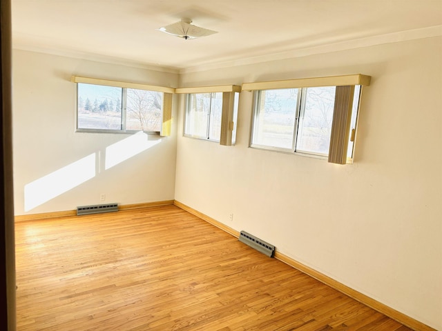 unfurnished room with crown molding and light hardwood / wood-style floors