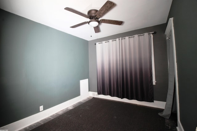 unfurnished room featuring dark carpet and ceiling fan