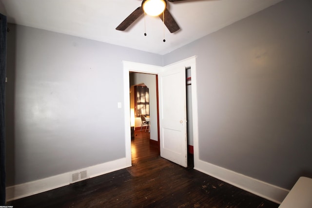 empty room featuring ceiling fan and dark hardwood / wood-style flooring