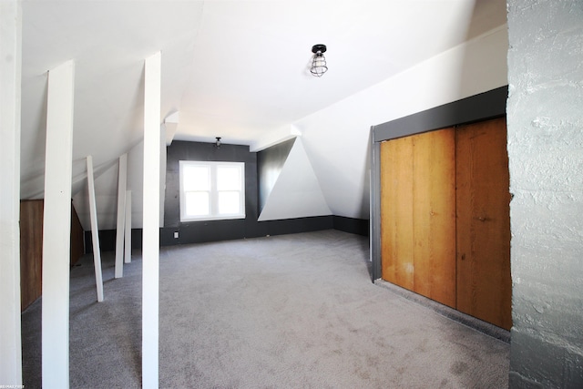 additional living space with lofted ceiling and light carpet