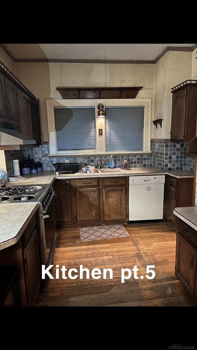 kitchen with ventilation hood, backsplash, range, dark brown cabinetry, and white dishwasher