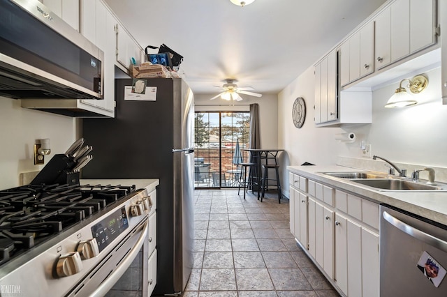 kitchen with white cabinetry, appliances with stainless steel finishes, sink, and ceiling fan