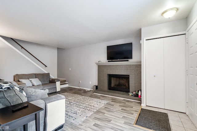 living room featuring a brick fireplace and light hardwood / wood-style flooring