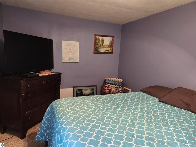 carpeted bedroom featuring a textured ceiling