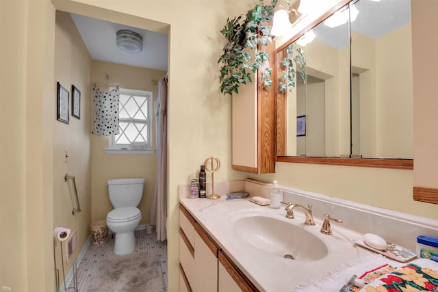 bathroom featuring tile patterned flooring, vanity, and toilet