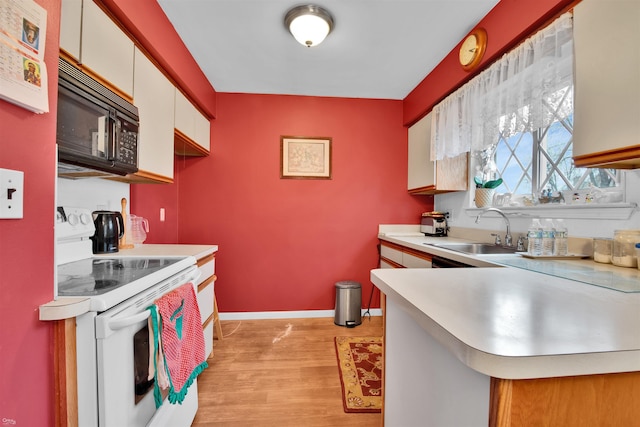 kitchen featuring white cabinetry, sink, electric range, and light hardwood / wood-style flooring