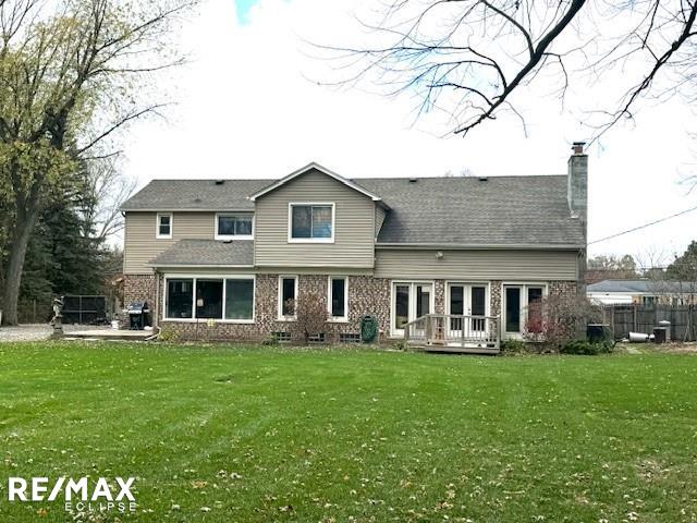 rear view of house featuring a lawn and french doors