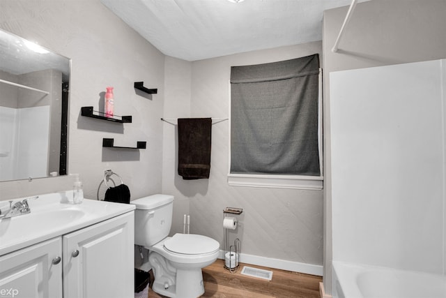 full bathroom featuring wood-type flooring, toilet, bathing tub / shower combination, and vanity