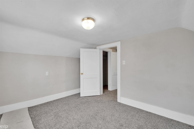 additional living space featuring vaulted ceiling and carpet flooring