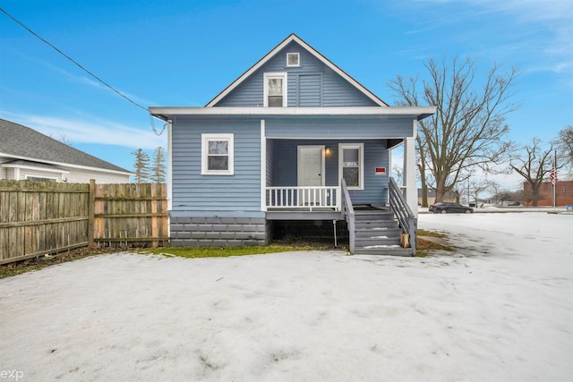 rear view of property featuring covered porch