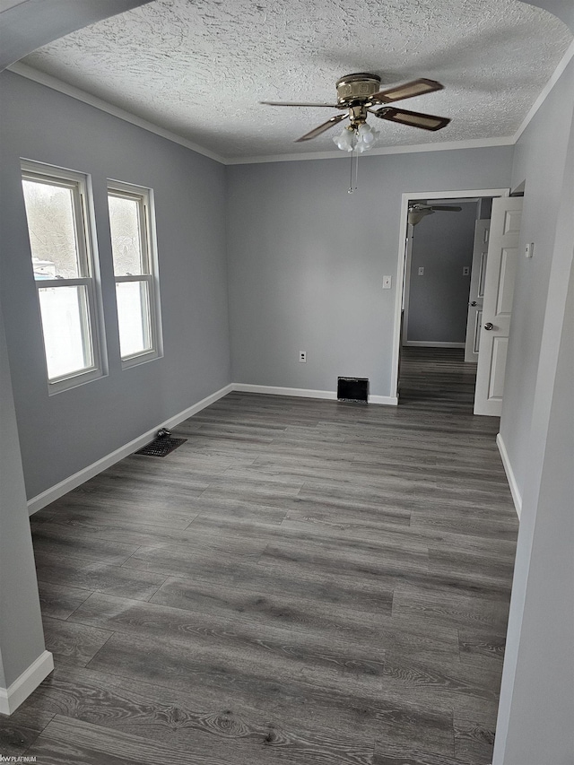 unfurnished room with ornamental molding, dark hardwood / wood-style floors, ceiling fan, and a textured ceiling