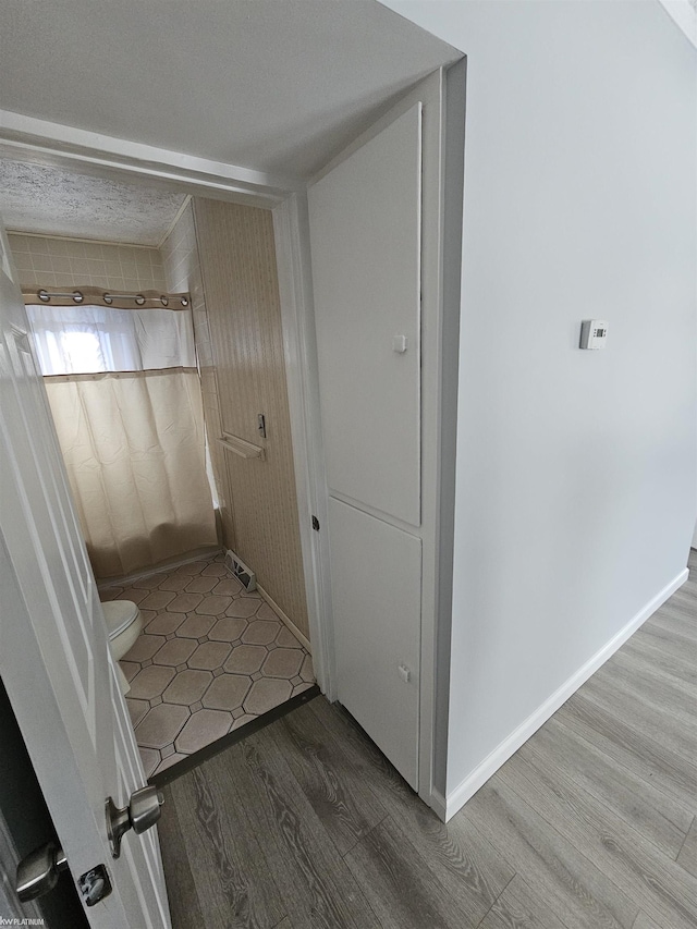 bathroom with hardwood / wood-style flooring and toilet