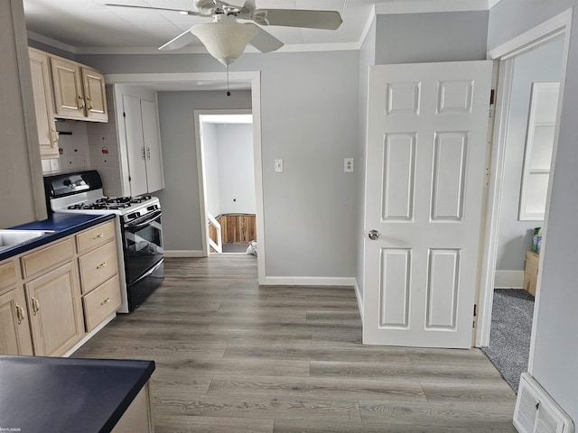 kitchen featuring crown molding, light brown cabinets, black range with gas stovetop, and light wood-type flooring