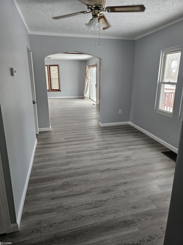 unfurnished room with hardwood / wood-style flooring, ceiling fan, ornamental molding, and a textured ceiling