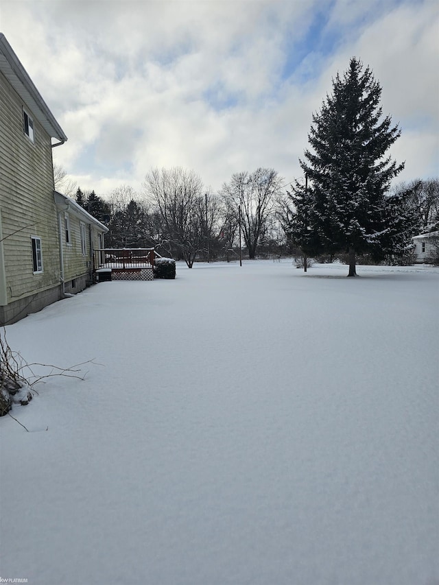 yard layered in snow with a deck