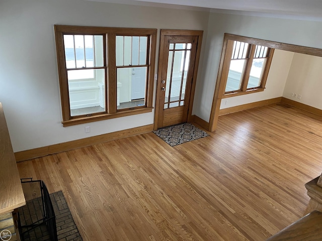 interior space with a water view and light hardwood / wood-style floors