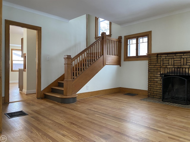 unfurnished living room with ornamental molding and light hardwood / wood-style floors