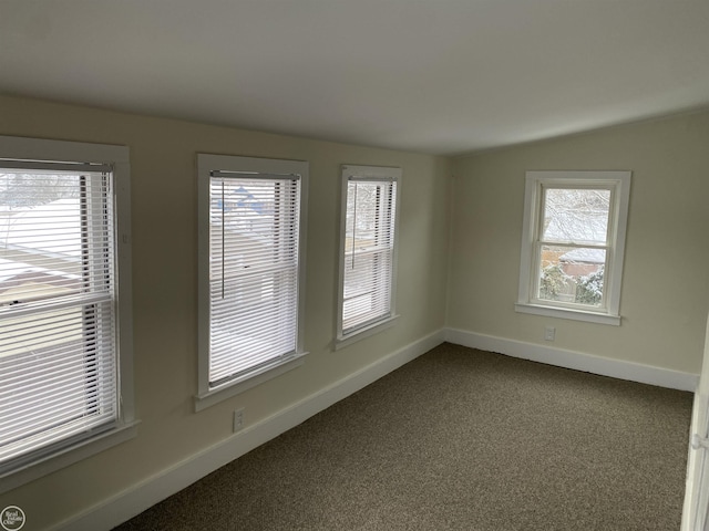 carpeted empty room featuring vaulted ceiling