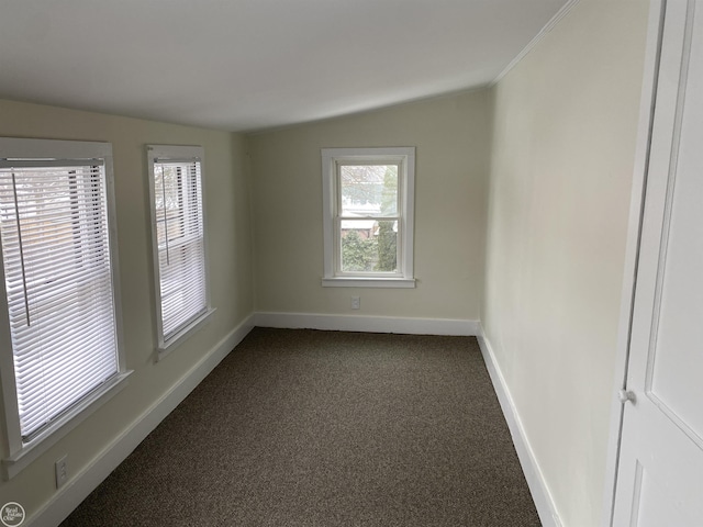 unfurnished room with lofted ceiling and dark carpet