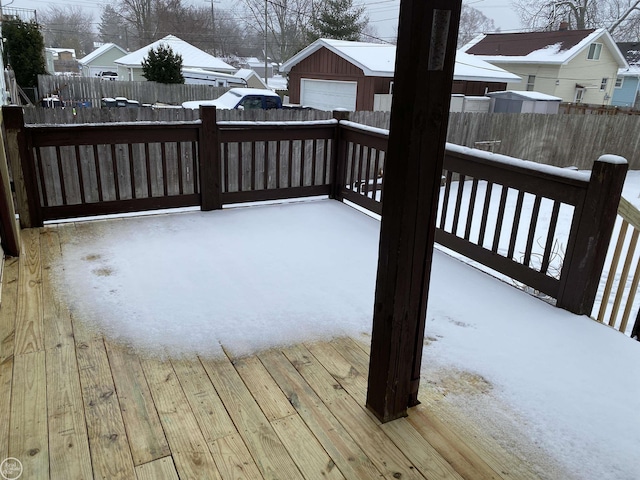 snow covered deck with an outbuilding and a garage