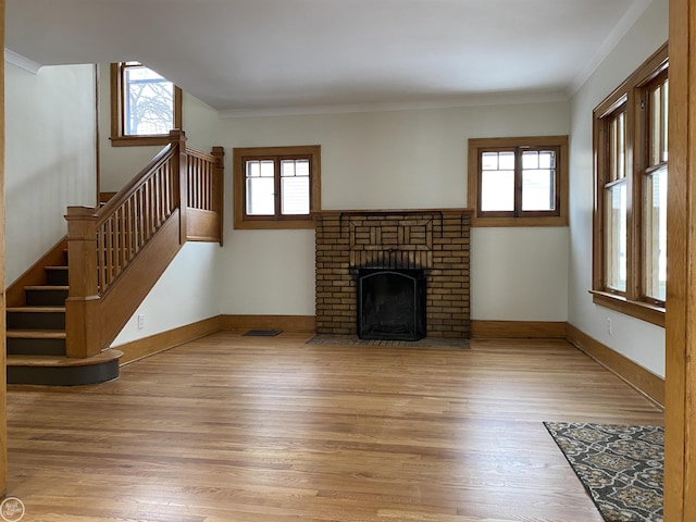 unfurnished living room with hardwood / wood-style flooring, crown molding, and a fireplace