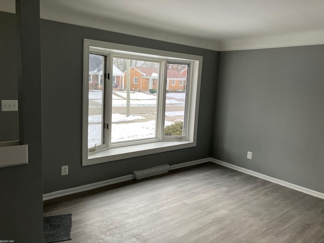 empty room with wood-type flooring and a healthy amount of sunlight