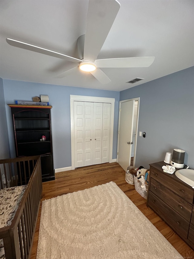 bedroom featuring ceiling fan, wood-type flooring, and a closet