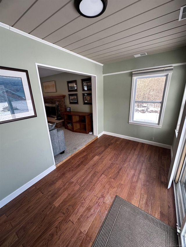 empty room with hardwood / wood-style floors and a brick fireplace