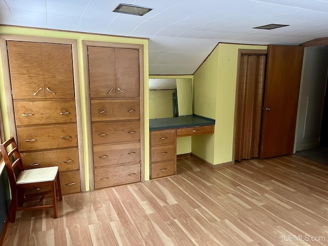 interior space featuring built in desk and light hardwood / wood-style floors