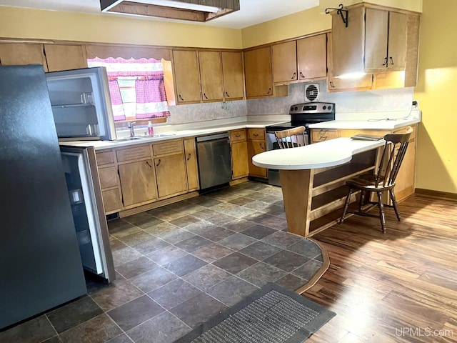 kitchen with stainless steel appliances, sink, and dark hardwood / wood-style flooring