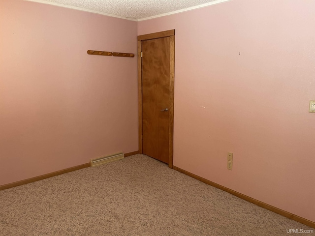 unfurnished room featuring crown molding, a textured ceiling, and carpet