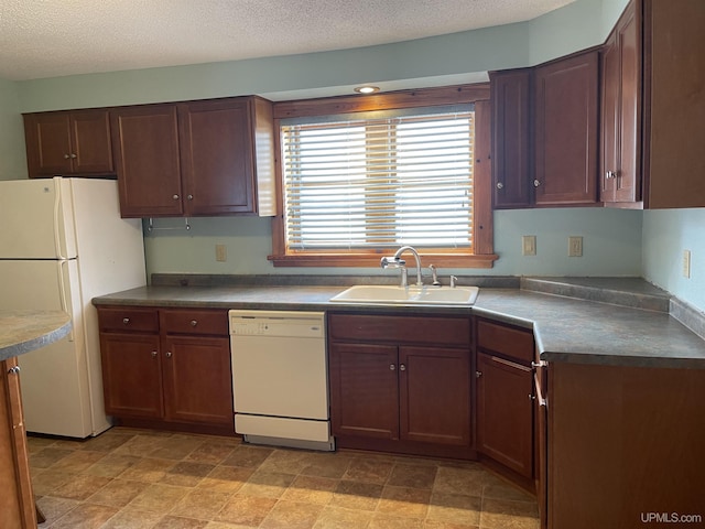 kitchen featuring sink, white appliances, and a textured ceiling