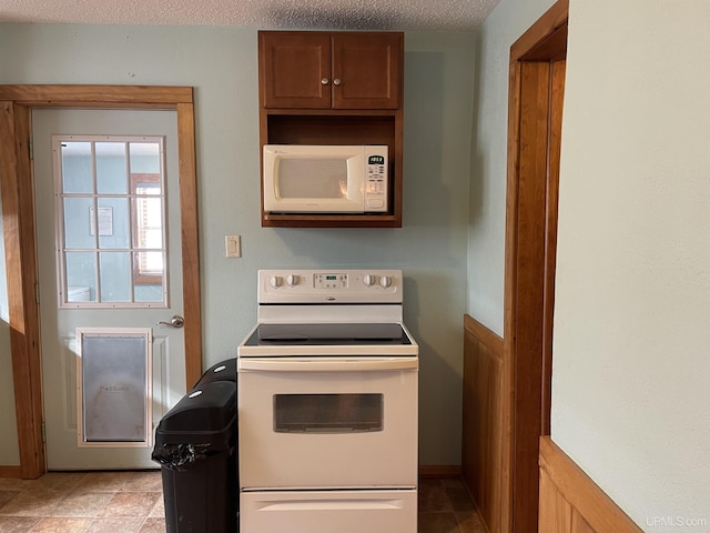 kitchen featuring white appliances and a textured ceiling